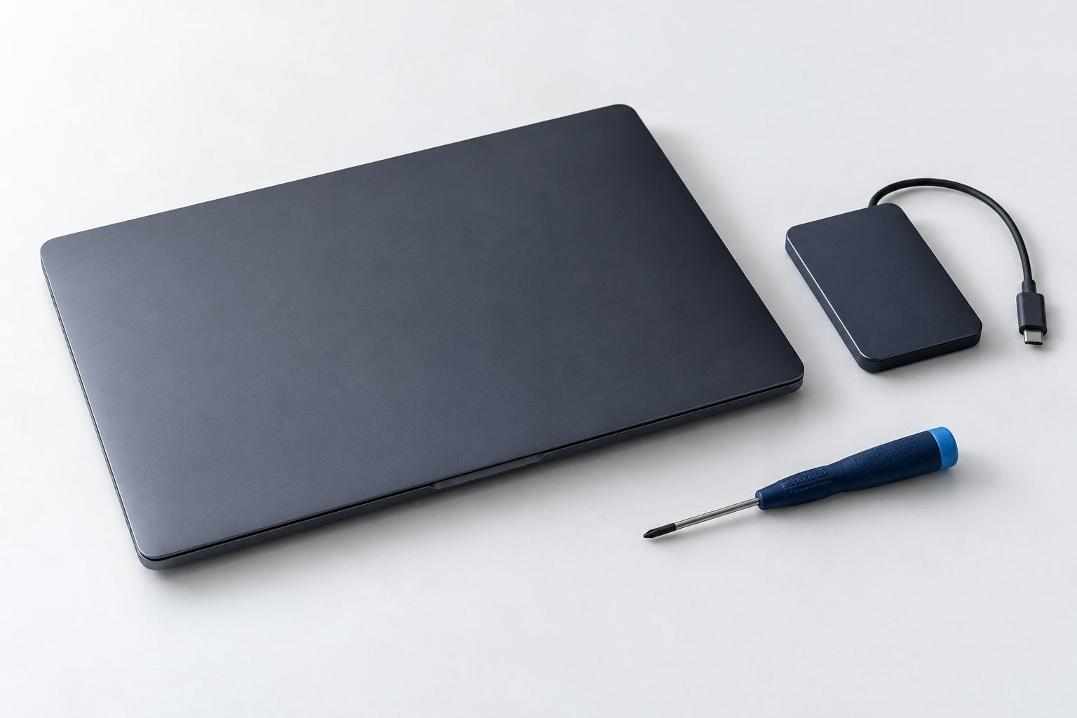 Composición ilustrativa de una notebook, un dispositivo externo y una herramienta